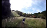草地の斜面を走るMTBの動画サムネイル